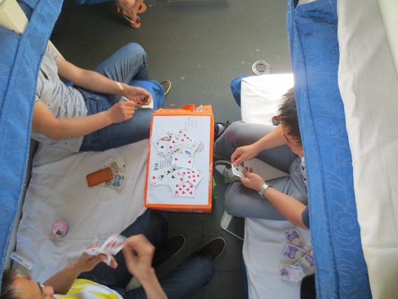 A few guys playing cards on the train to Chengdu