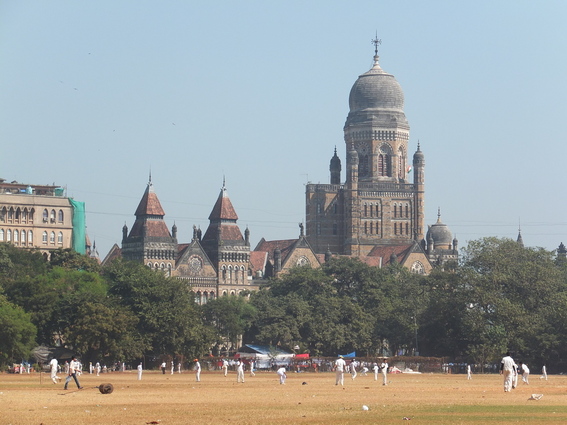 People playing cricket in the field in Mumbai