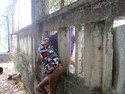 Marius climbing through a whole in the fence of a building site.