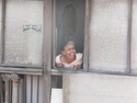 Old woman leaning out the window to join in the happiness