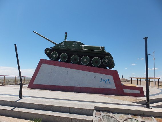 Boy standing on a tank in the desert