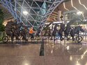 Tony riding along with the animals on a tandem bicycle at the Doha airport