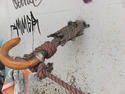 Umbrella sticking out of a wall and holding a rope
